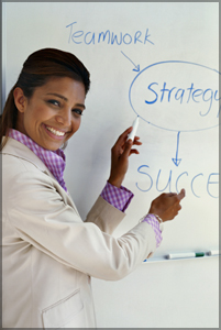 Woman standing a whiteboard with Teamwork, Strategy and Sucess written on it.